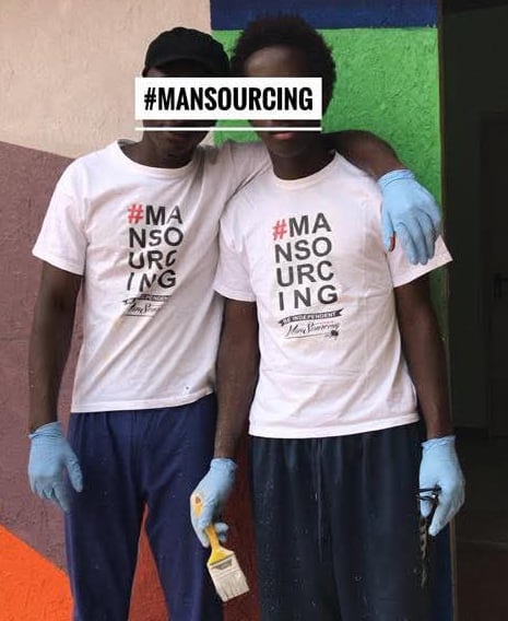 Due partecipanti al progetto Mansourcing posano con camicie bianche e strumenti di pittura