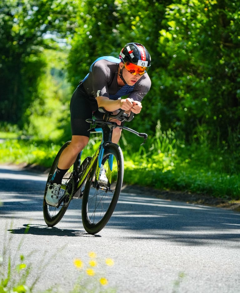 Un triathlète est allongé sur son vélo pour plus d'aérodynamisme