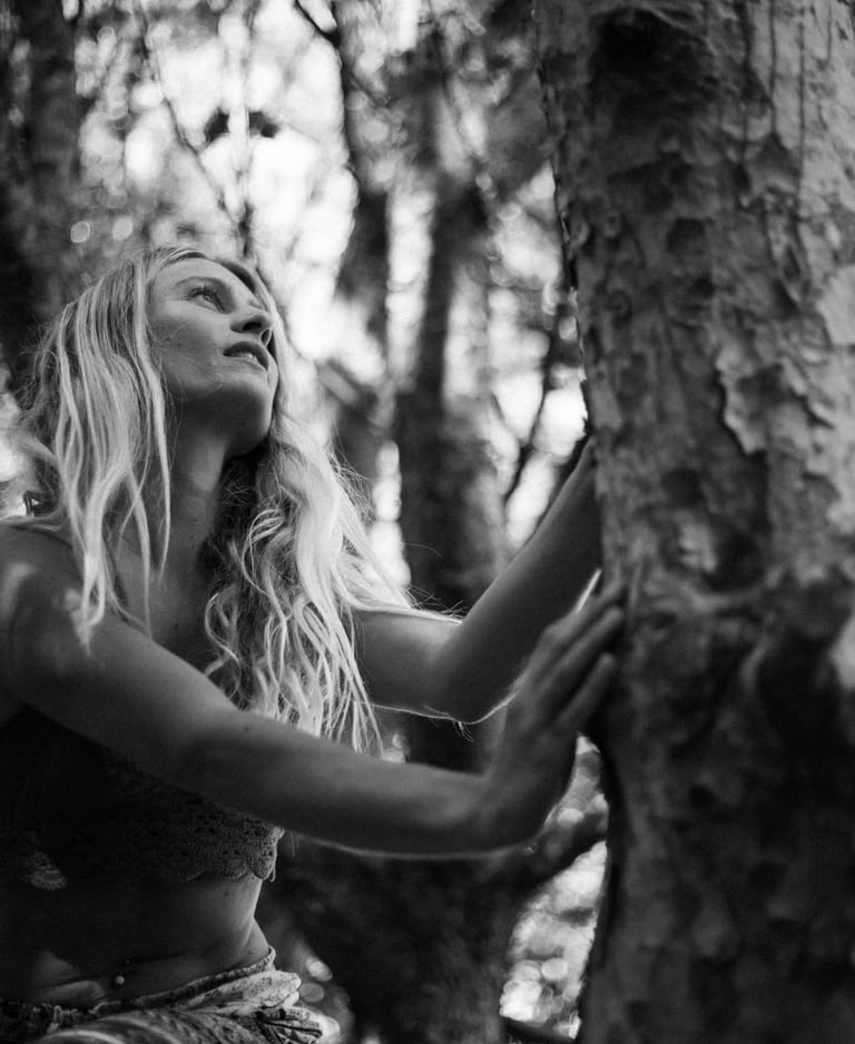 una donna in natura appoggiata ad un albero