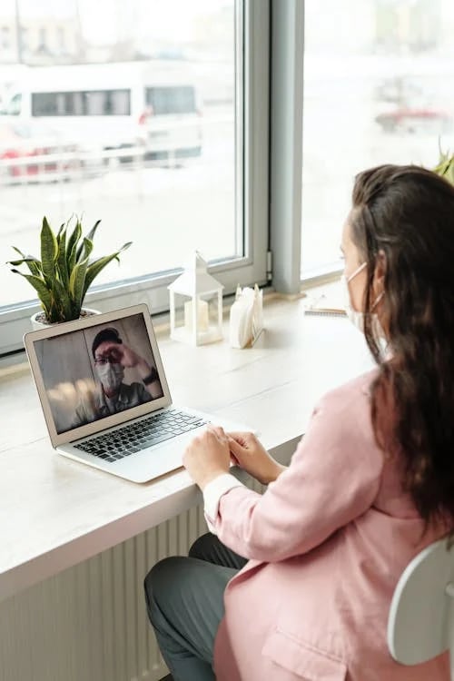 a woman sitting at a desk with a laptop computer