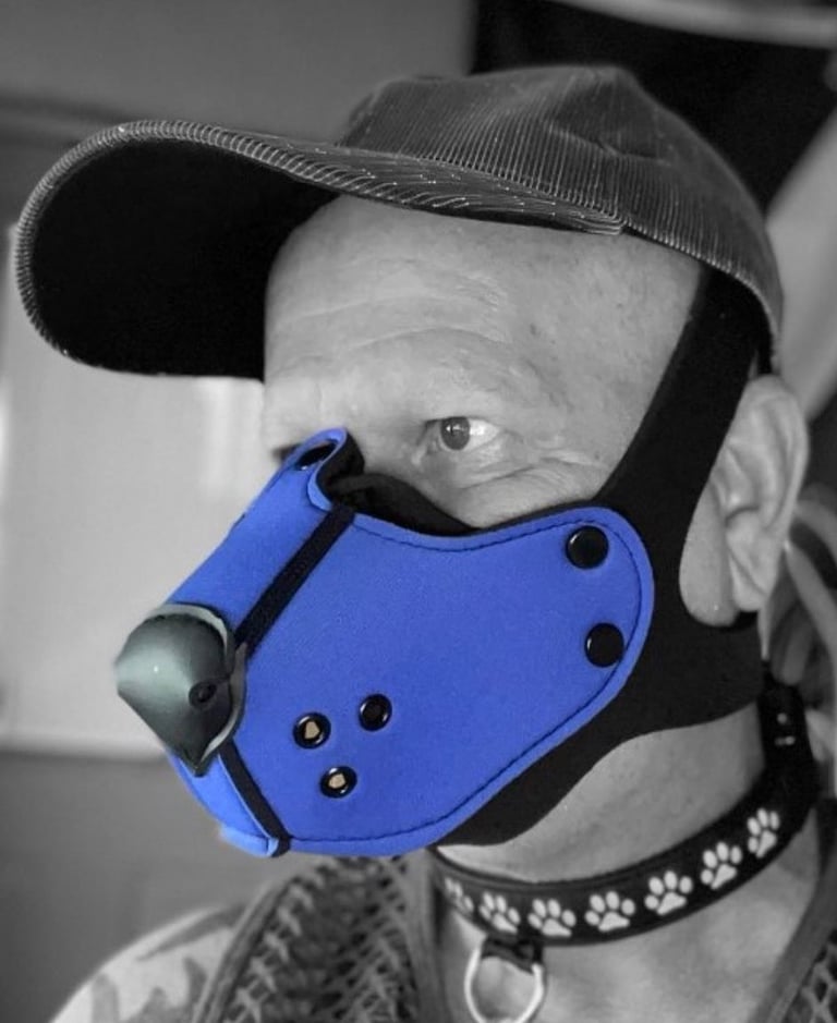 Man in pup half-mask and ball cap.