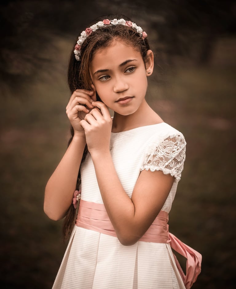 niña de comunión tocándo su orejita