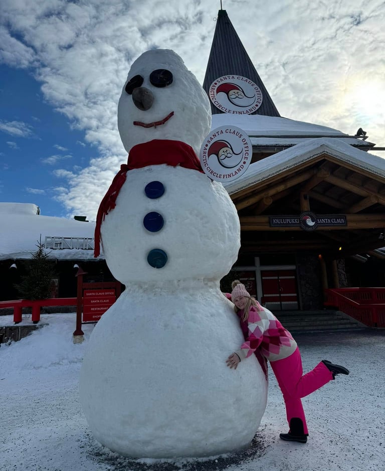 A tourist hugs a giant snowman at Santa Claus Village in Rovaniemi, Lapland, Finland.