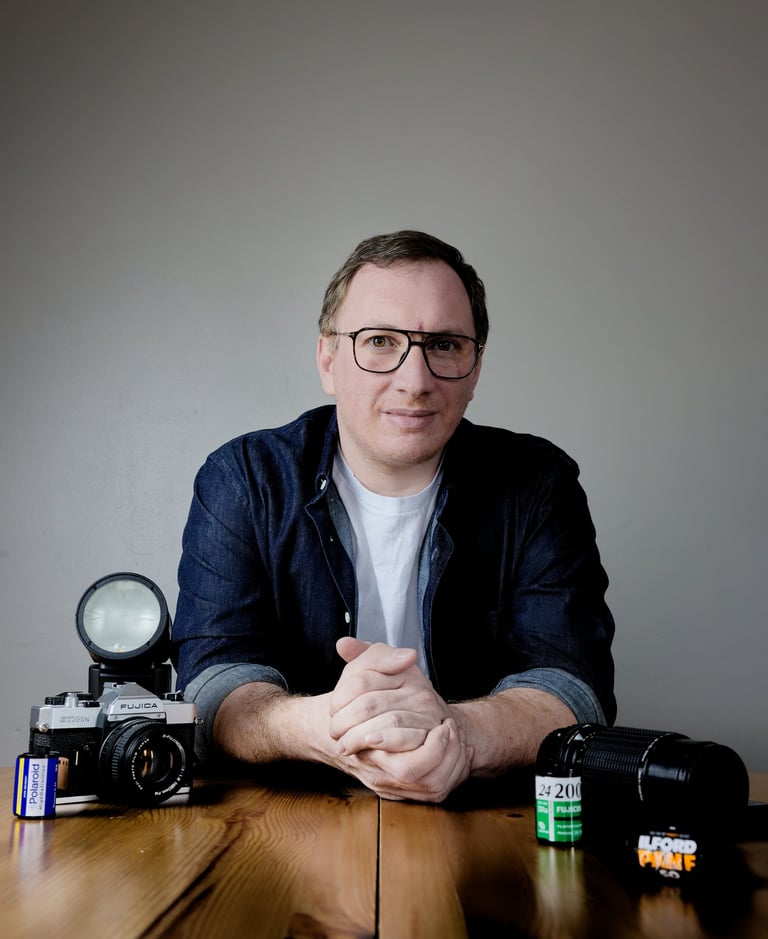 a man sitting at a table with a camera and a camera
