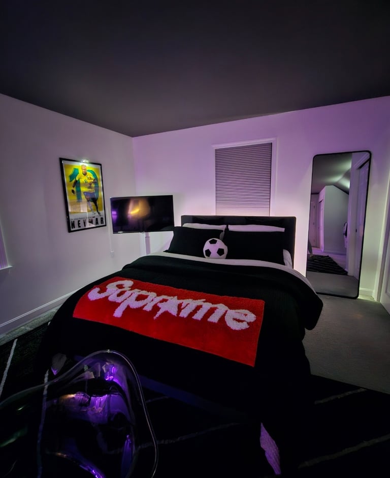 Modern bedroom with Supreme throw blanket, soccer ball pillow, and purple LED ambient lighting.