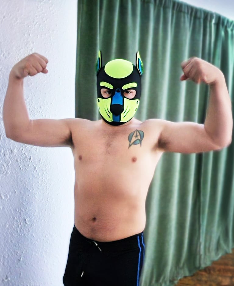 Man flexing for a pose in his pup mask.