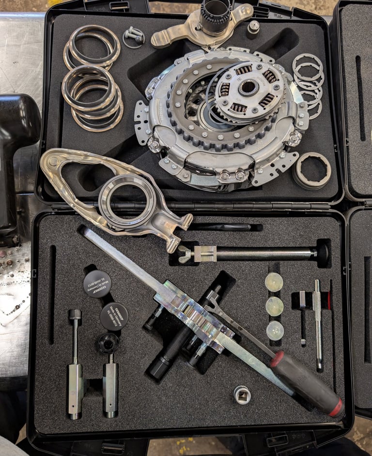Professional dual-clutch transmission tool kit with clutch assembly and specialized repair hardware.