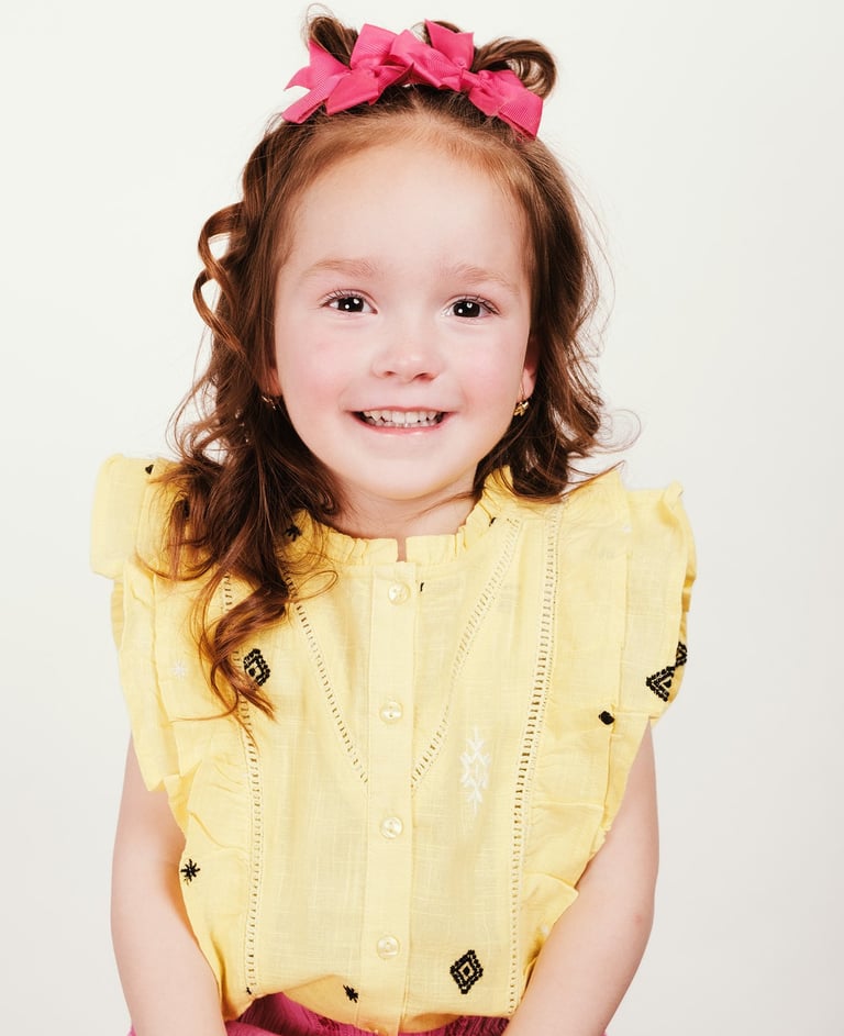 portrait of a little girl with a pink bow tie and a pink dress