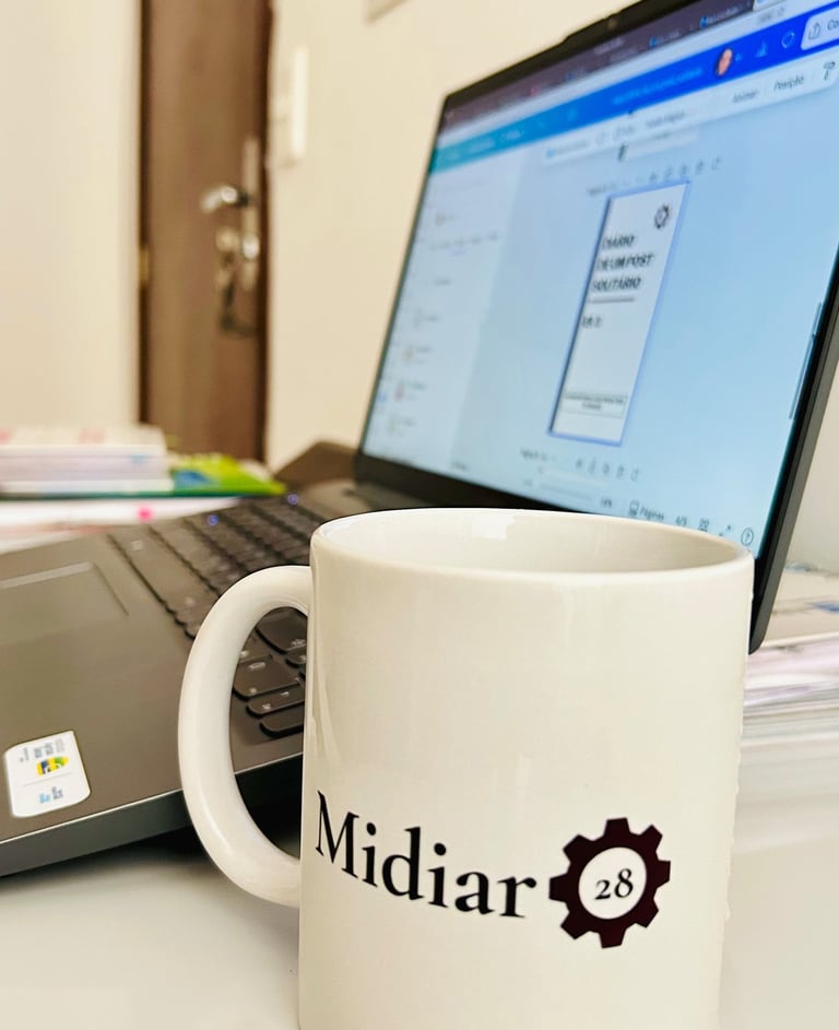 caneca-escrito-midiar-28-em-cima-de-uma-mesa-com-um-computadpr