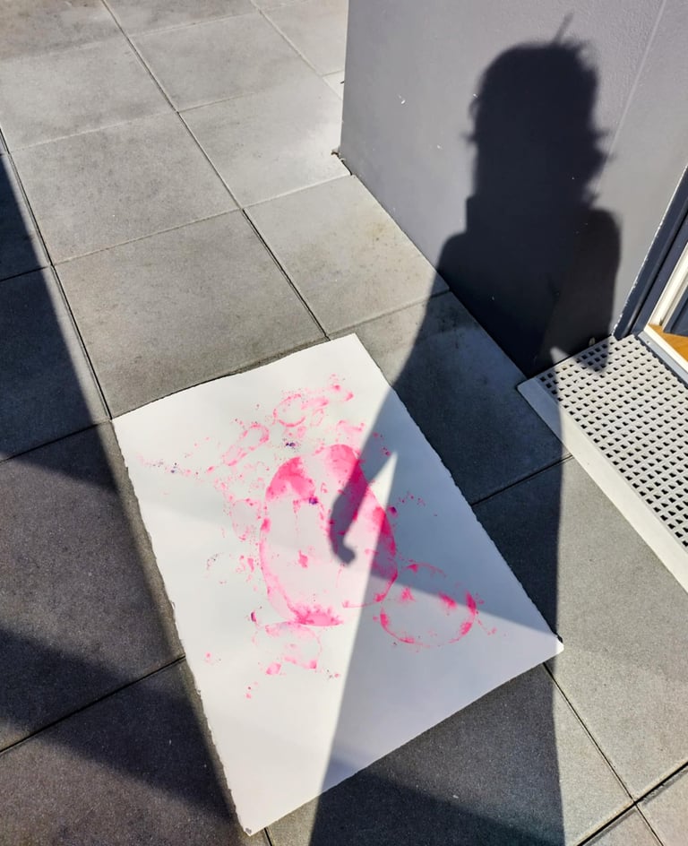 photo de l'ombre de l'artiste sur son œuvre à l'aquarelle rose