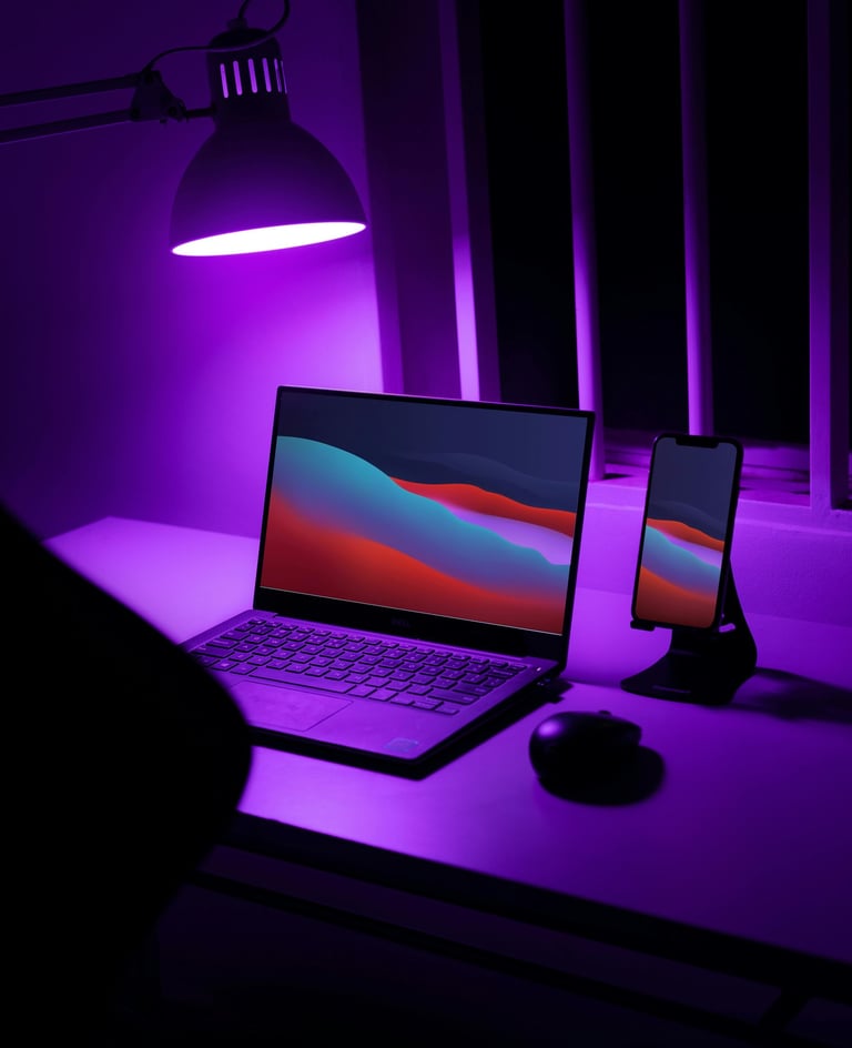 a laptop computer sitting on a desk with a purple light
