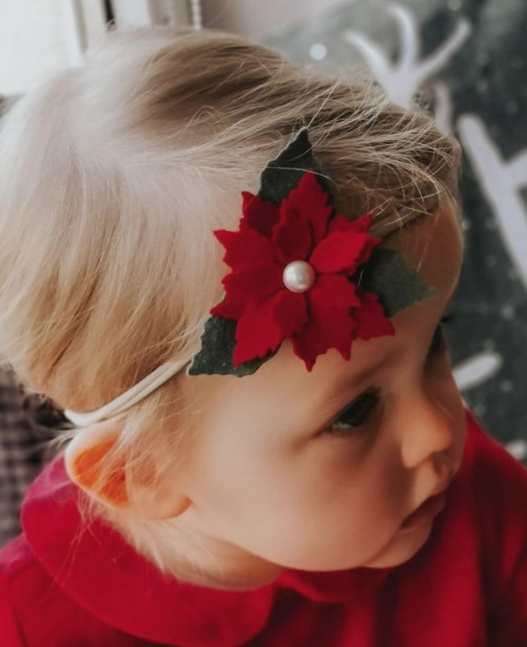 dziewczynka z czerwonym kwiatem na głowie