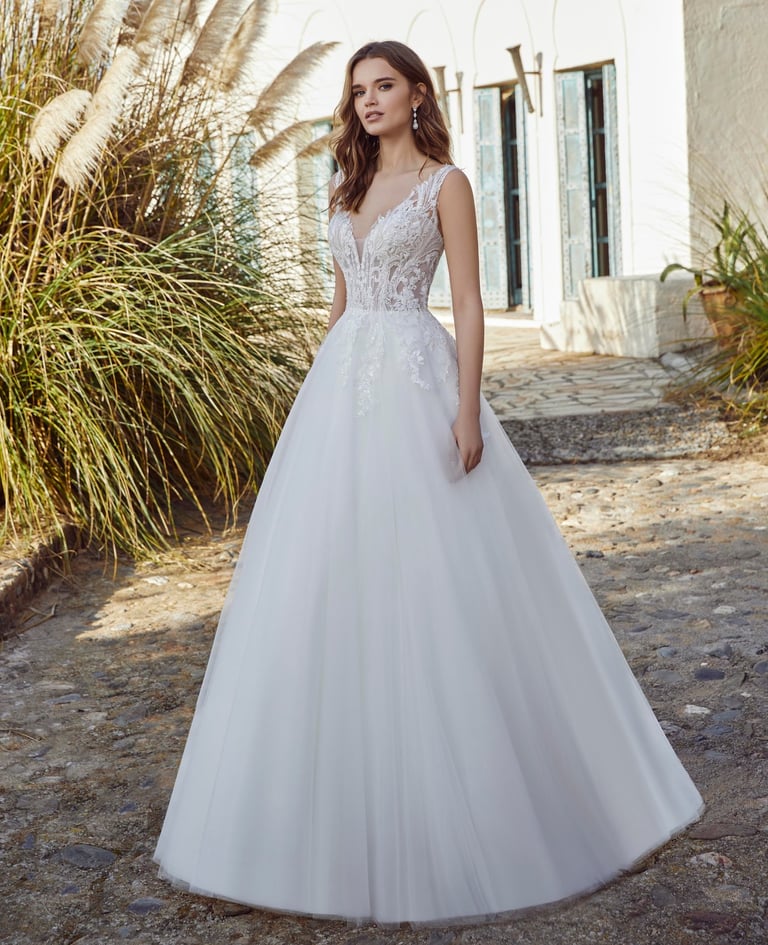 a woman in a white wedding dress standing in front of a house
