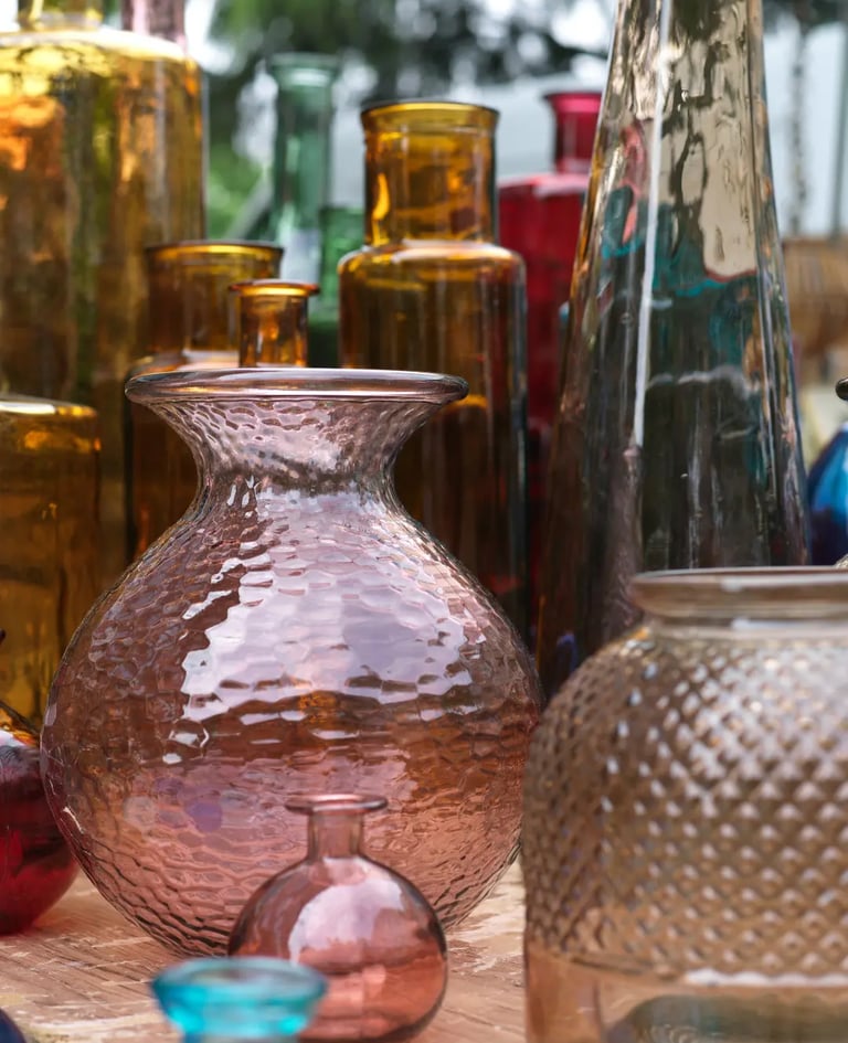 vases jaunes et roses de différentes formes et tailles sur un étal dans un marché aux puces
