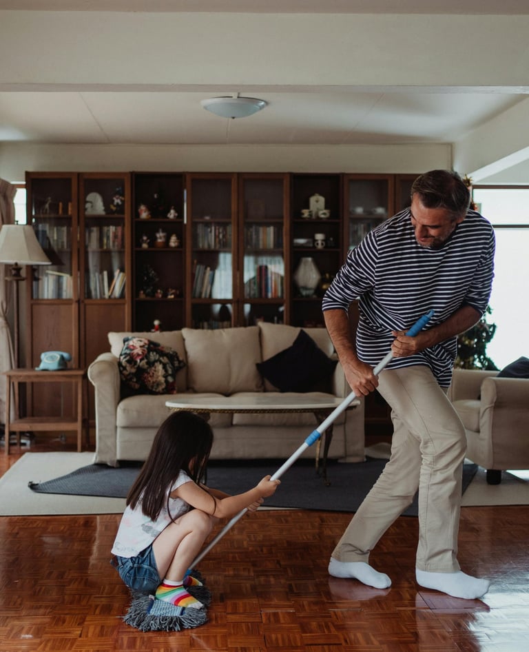 Father playing with daughter on wood floor in custom house