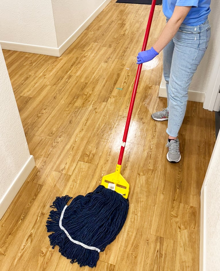 Lady cleaner from Chez Cleaning Services cleaning a floor with a mop
