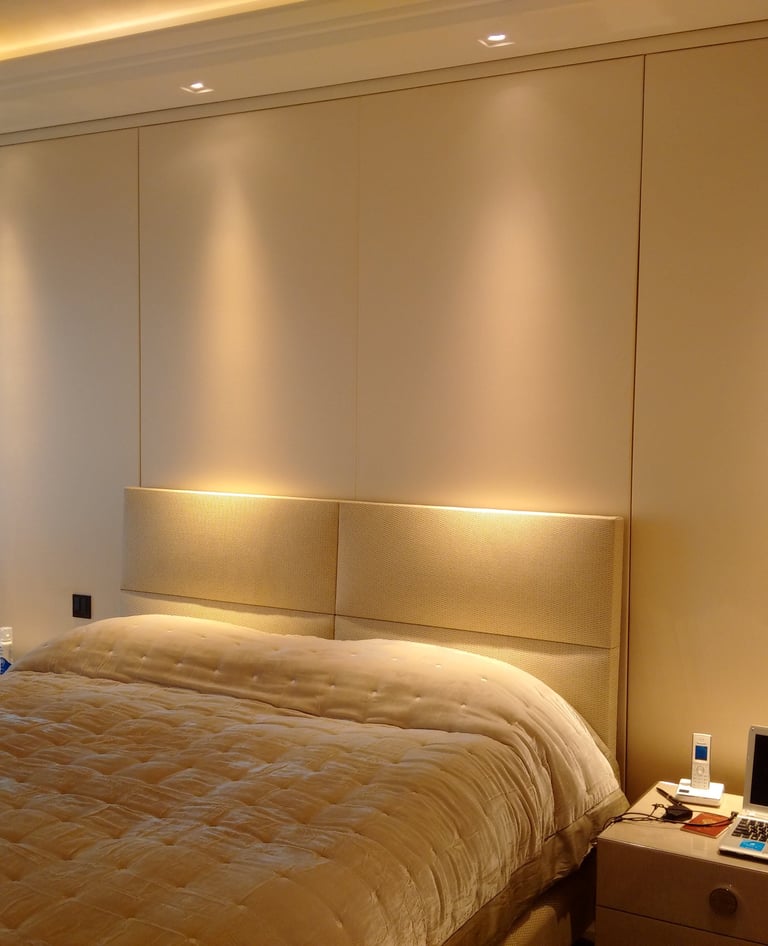 Soft fabric wall finish used behind a bedroom headboard.