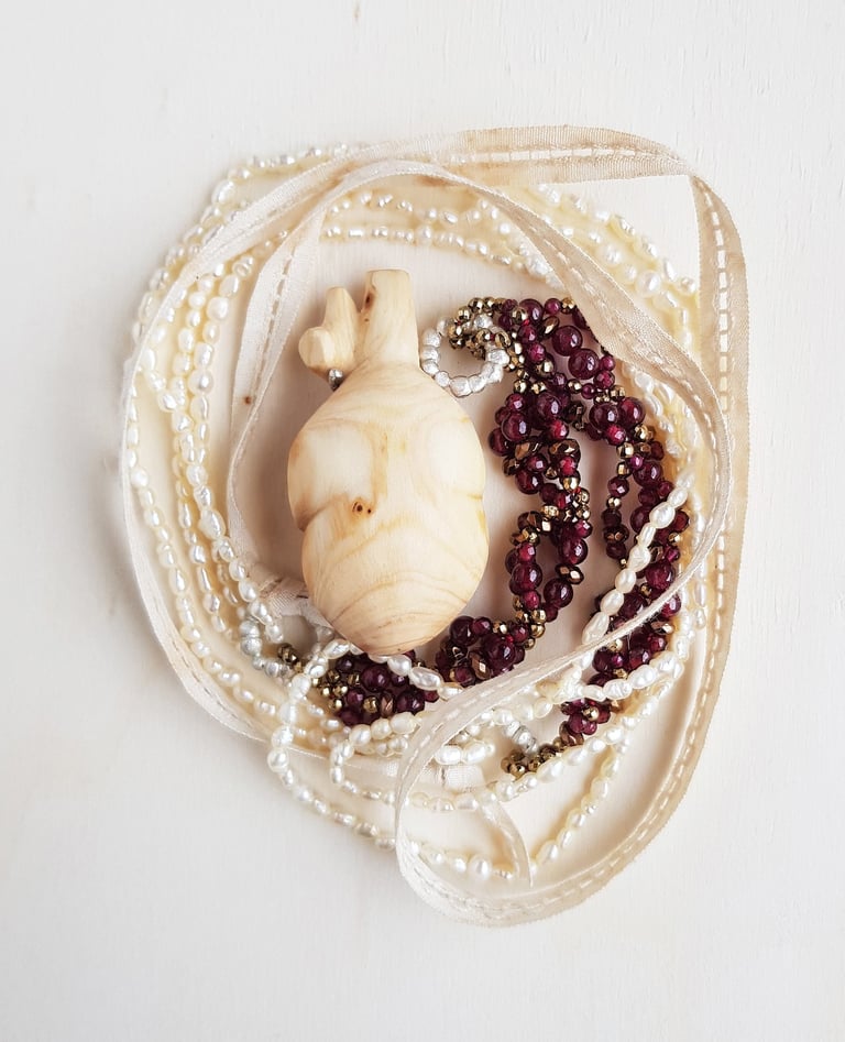 Wooden heart withe accompanied by granates, hematites, pearls, silver and antique lace. Wearable Art