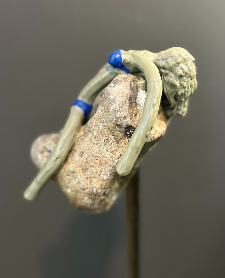 Iron sculpture with stone on iron pedestal