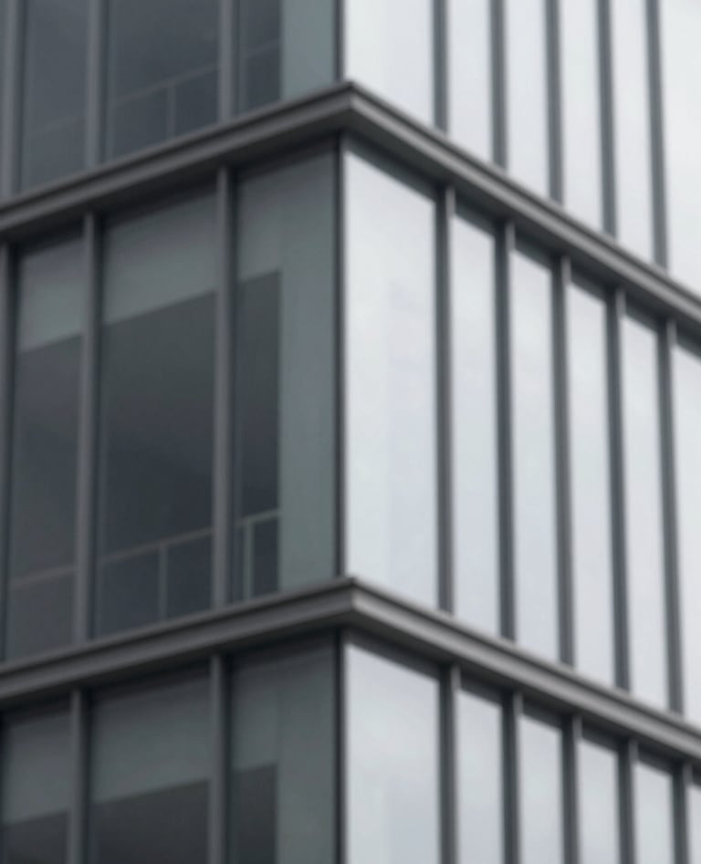A close-up detail of a minimalist building corner showing the intersection of glass and steel, with a refined aesthetic using tones of #F7F9FB and #262F38.