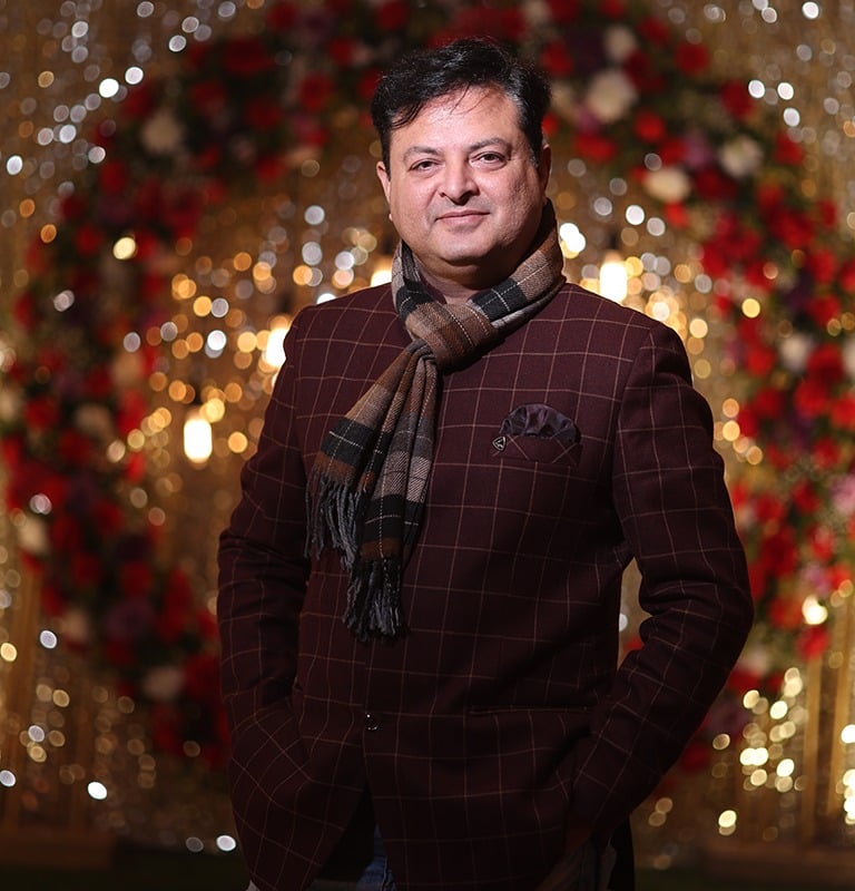a man in a suit and tie with a scarf around his neck