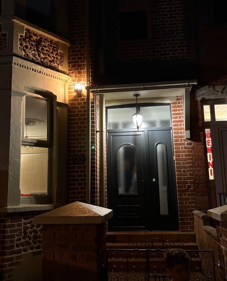 A front door and window illuminated by bright outdoor lights