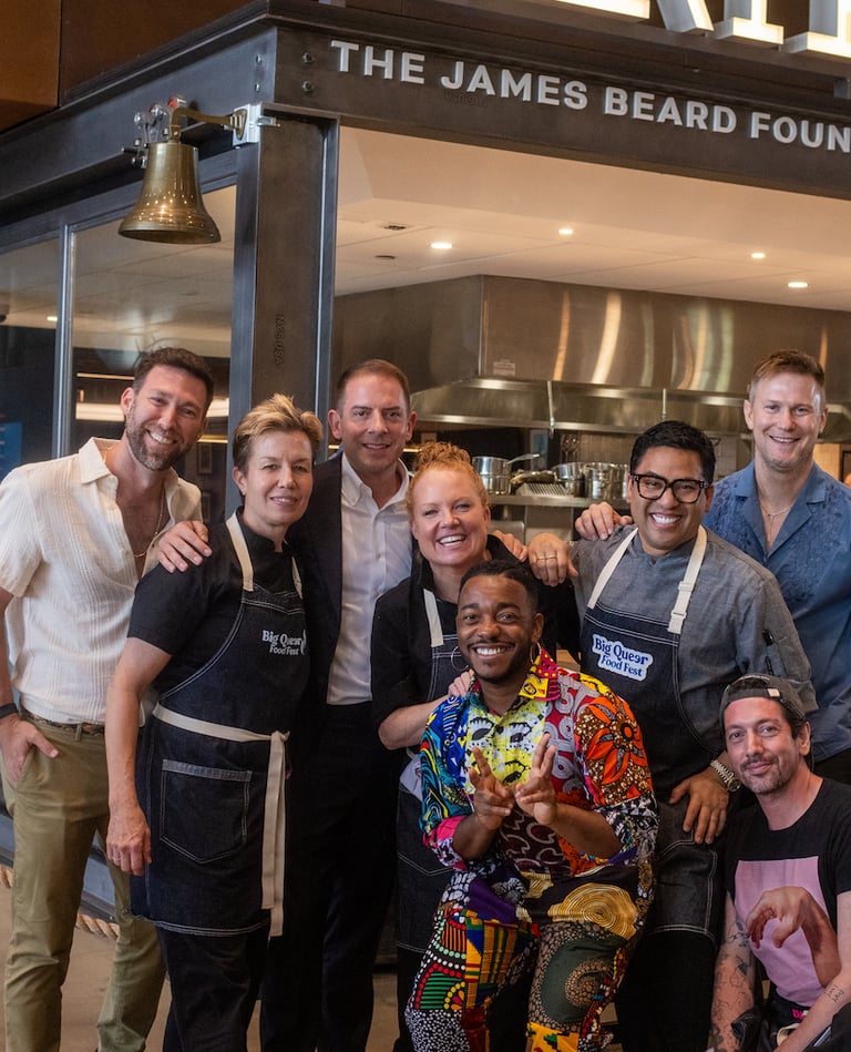 A group of chefs and BQFF staff posing in front of a The James Beard Foundation's Platform venue
