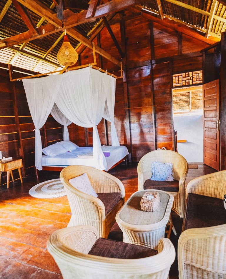 Toska bungalow bedroom with canopy bed, wooden walls, and natural light
