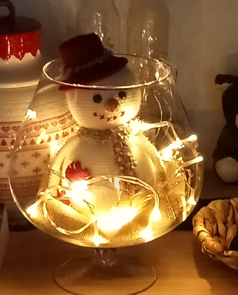 Bonhomme de neige avec une écharpe et un chapeau dans un grand vert à cognac