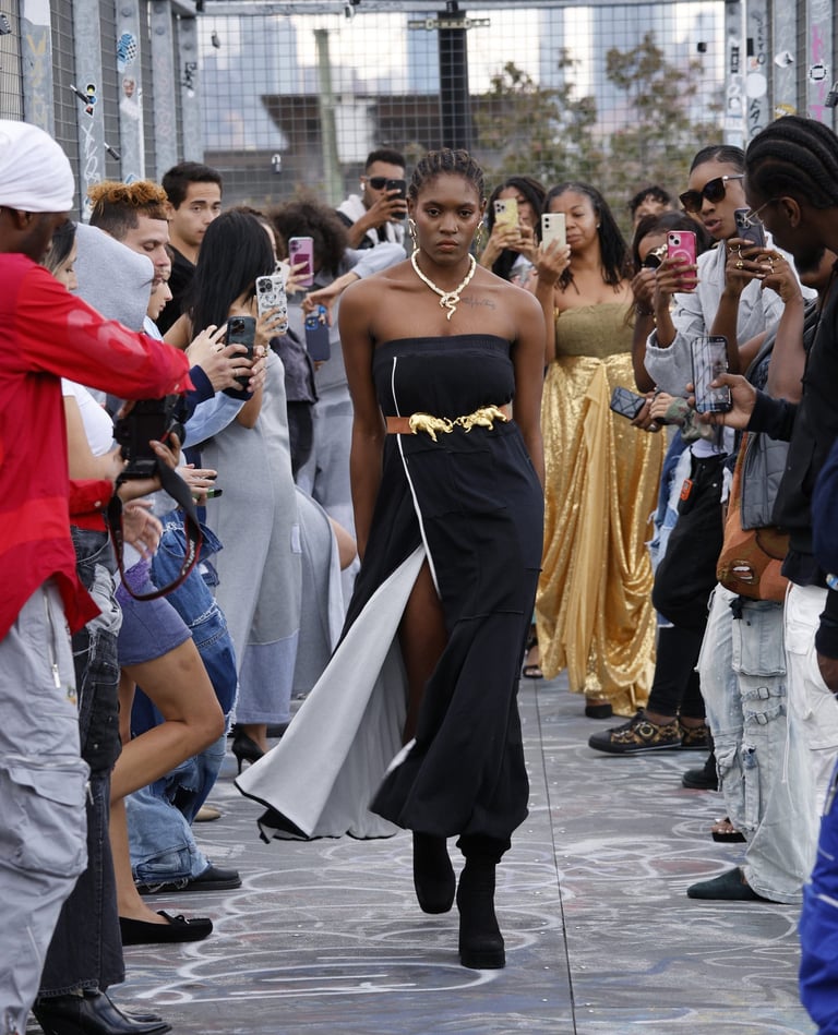 a woman in a black dress walking down a street
