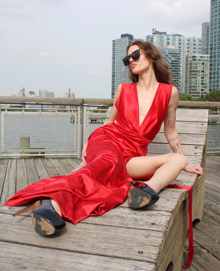 a woman in a red dress sitting on a bench