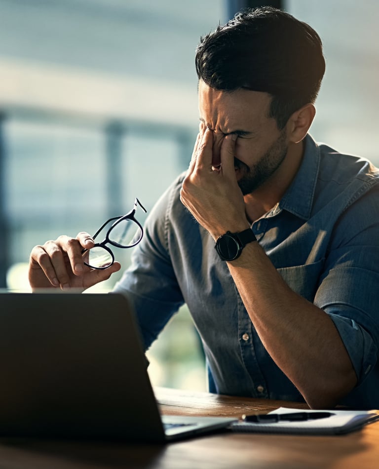 Ein Mann im Büro der zu viel Stress spürt