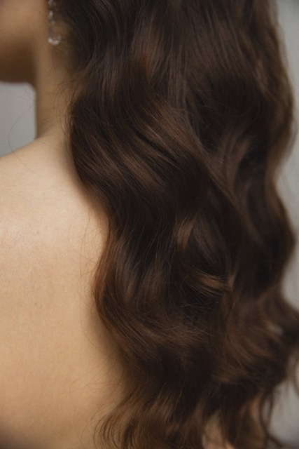 Une mariée de dos avec sa longue chevelure coiffée avec des vagues Hollywood waves.