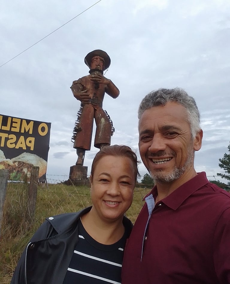 Foto de Adriano e Andréa, ao fundo, escultura de meta Gaúcho gigantel