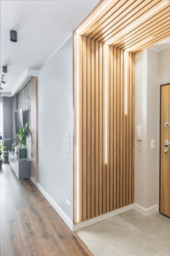 a hallway with a wooden paneled wall and a wooden door