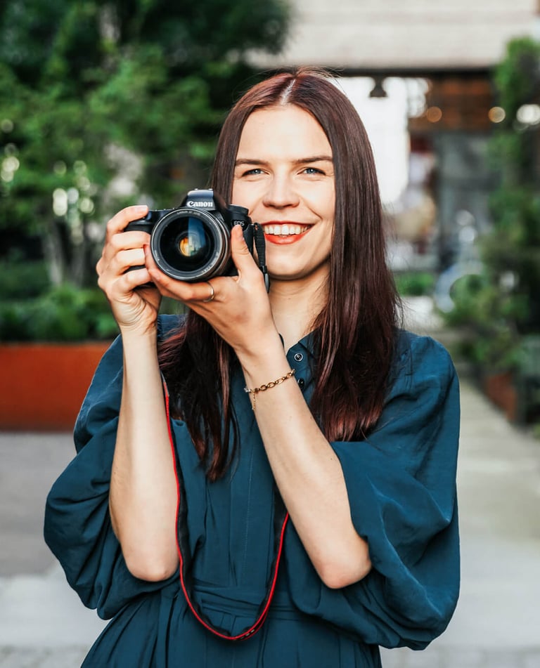 Smiling photographer holding a camera, radiating passion for photography