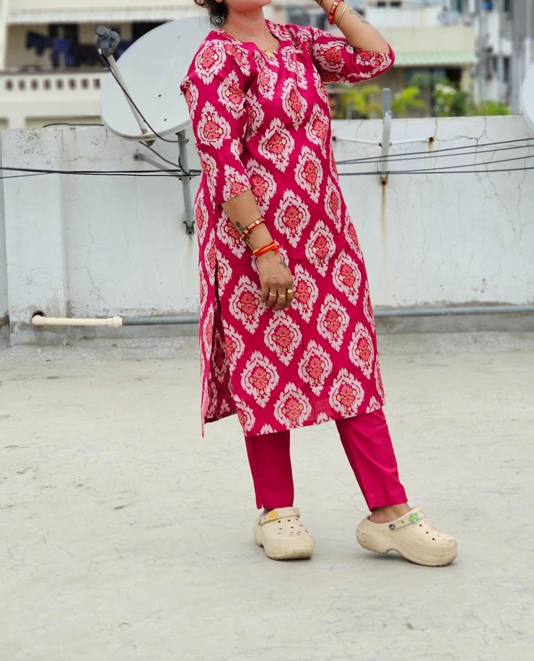 a woman in a pink dress and white shoes