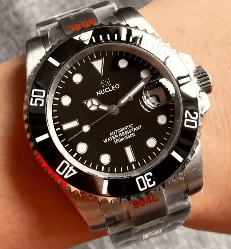 homage submariner acciaio quadrante e lunetta unidirezionale neri con data a ore 3 indossato al polso