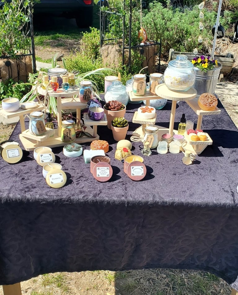 Handmade Organic Beeswax candles and artisan soaps displayed on wooden stands.