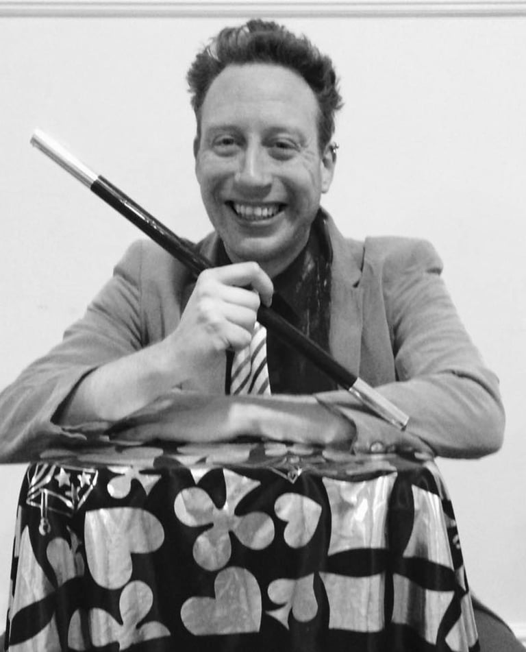 a man in a suit and tie is smiling and holding a knife and knife