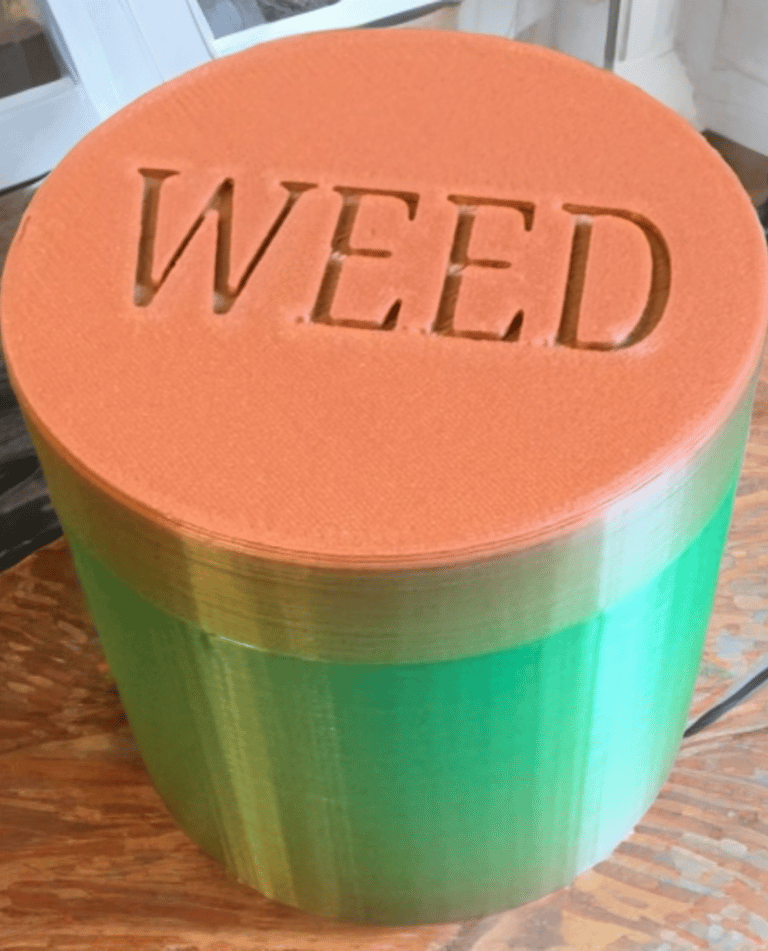 barattolo per la cannabis verde e tappo arancione con la scritta weed incisa