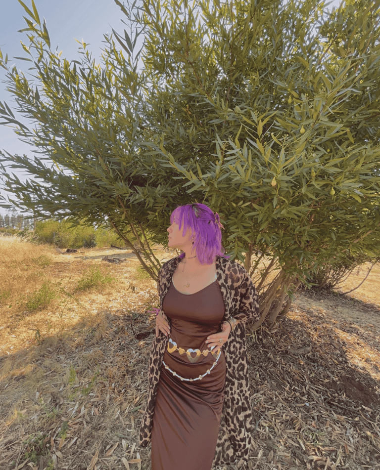 a woman (Angelina Young) with purple hair and a leopard print dress