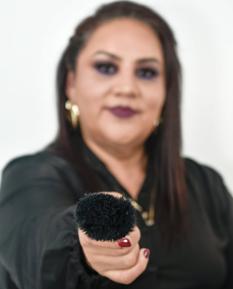 Artista de maquillaje profesional sosteniendo una brocha grande de polvo negro .