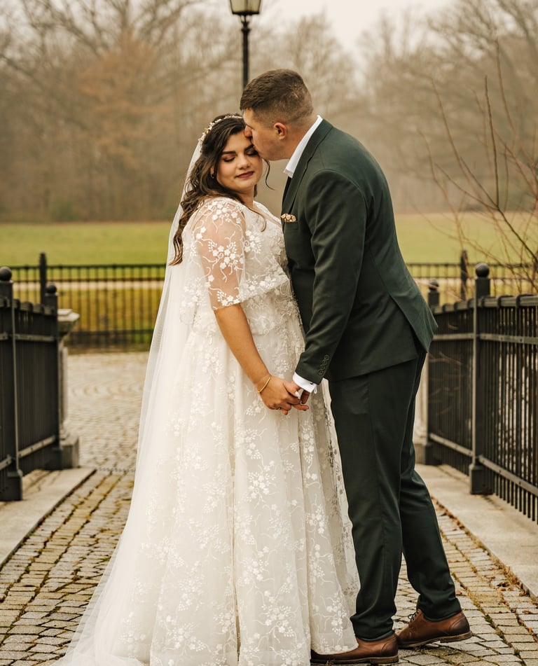 panna młoda i pan młody stojący na ceglanym chodniku