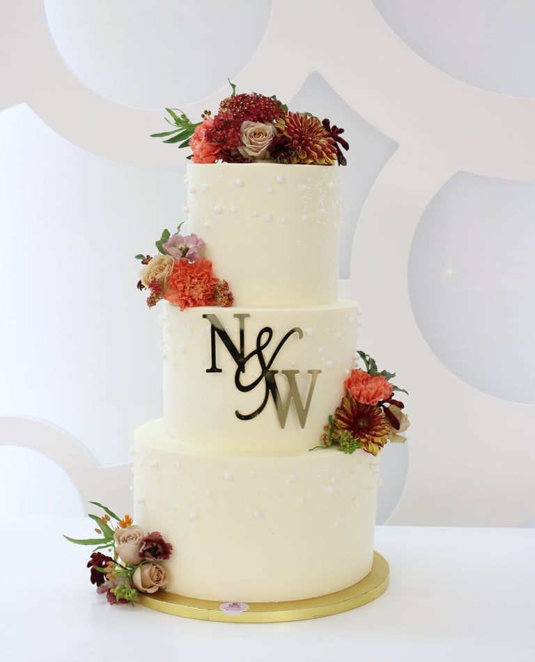 Tarta de boda personalizada de tres pisos con flores naturales, elaborada artesanalmente en Madrid