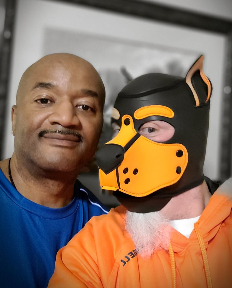 2 men - 1 in a pup mask, posing together