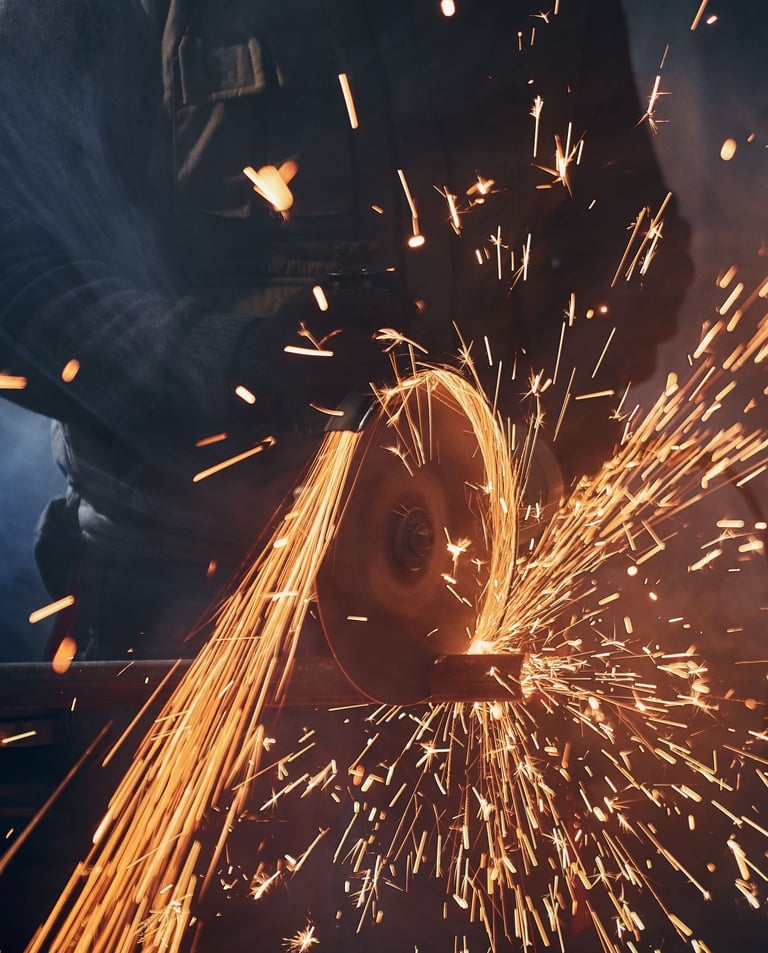 a man grinding a piece of metal with sparks