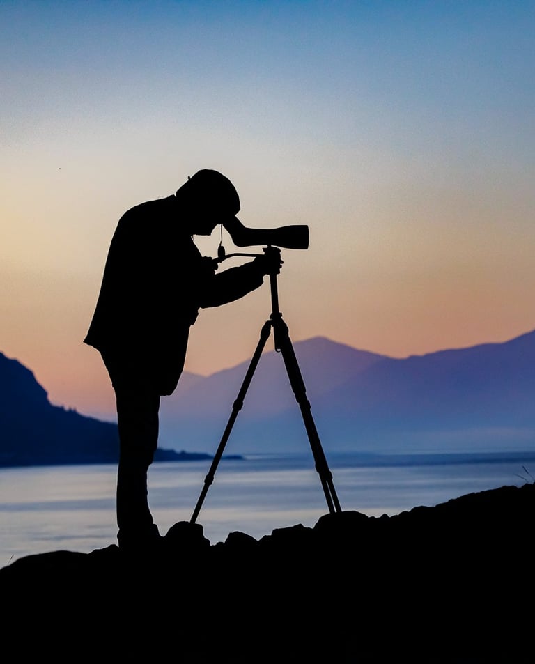 a man standing on a rock with a camera and a tripod