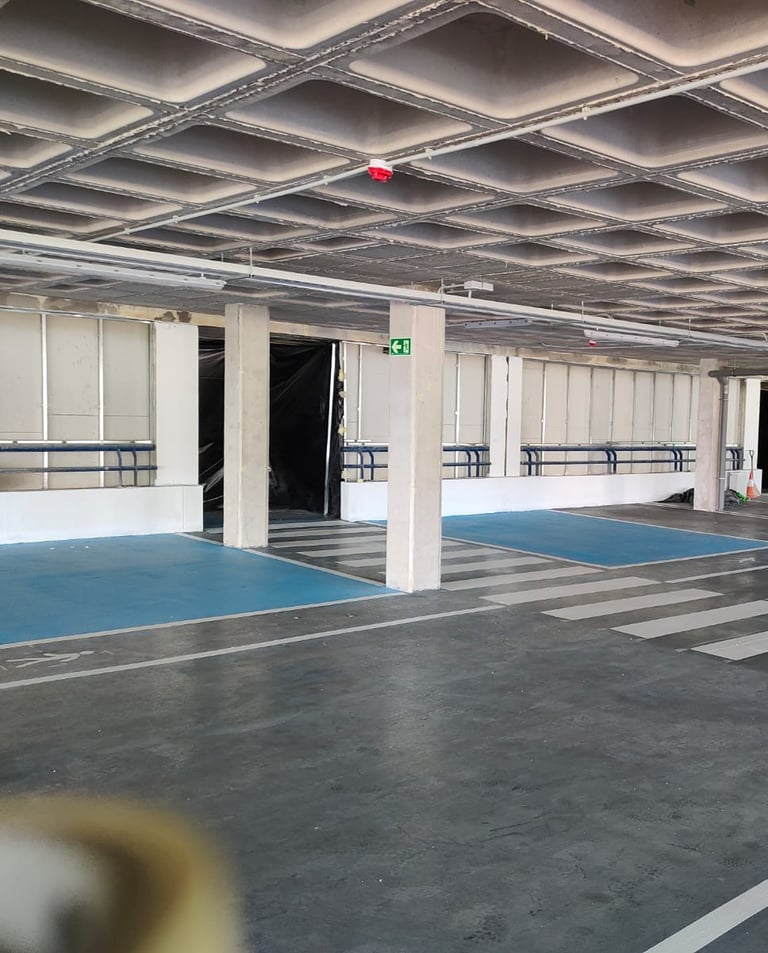 Señalización horizontal en parking privado con líneas y pictogramas