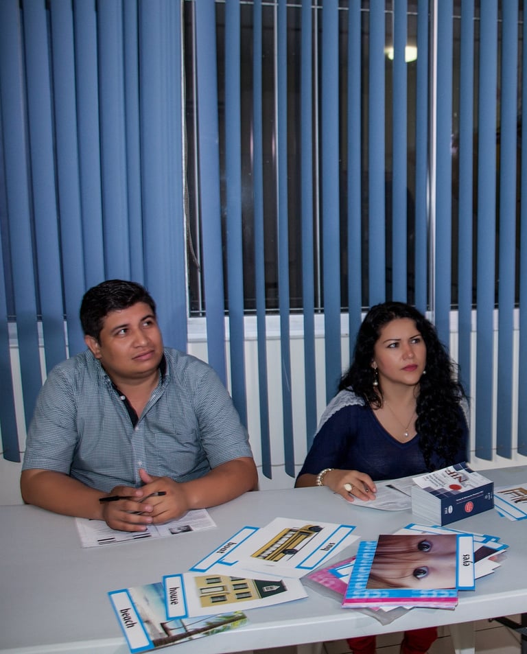a woman standing in front of a table with a man in a blue shirt